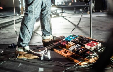 Gitaristens sko ved et pedalbrett på en opplyst scene