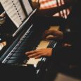 Pianist spiller på et blankt piano med noter på notestativet