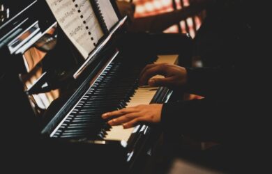 Pianist spiller på et blankt piano med noter på notestativet